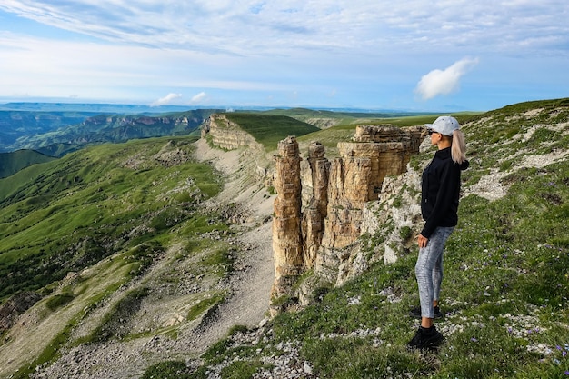 Une fille sur le fond de deux moines rochers dans un nuage plateau Bermamyt République KarachayCherkess