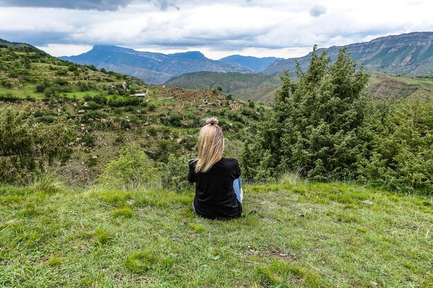 Une fille sur le fond du village de Kurib dans les montagnes du Caucase au sommet d'une falaise Daghestan Russie juin 2021