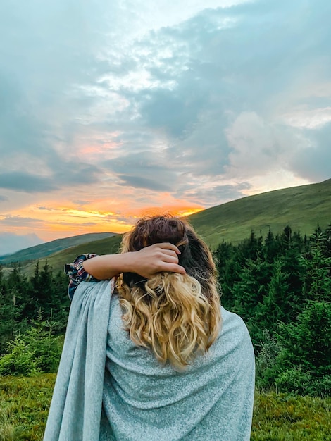 fille sur le fond de la forêt de montagnes et du coucher du soleil se penche sur la randonnée de voyage à distance