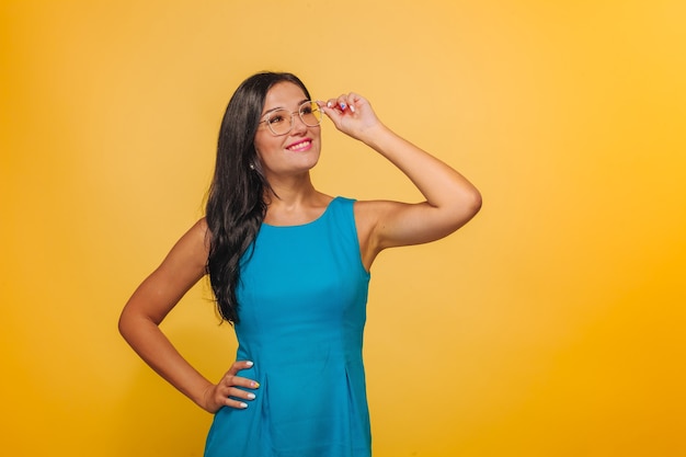 Fille sur fond jaune, toucher des lunettes