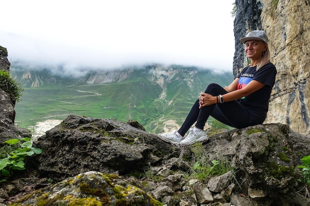 Une fille sur le fond d'un paysage de montagne dans les nuages Bol en pierre au Daghestan Russie