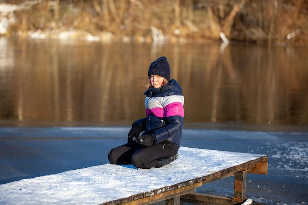 Fille sur le fond d'une rivière gelée d'hiver