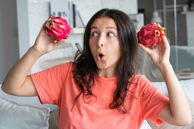 Fille et fruit du dragon. Fille joyeuse appréciant les fruits tropicaux.