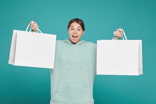 Fille gaie tenant des sacs à provisions