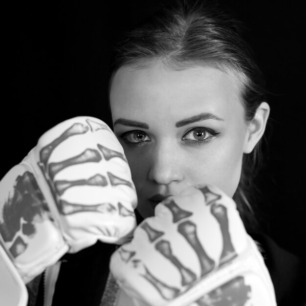 Fille en gants de boxe, image noir et blanc.