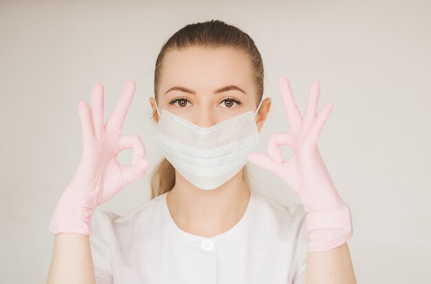 Fille en gants médicaux et un masque médical sur son visage