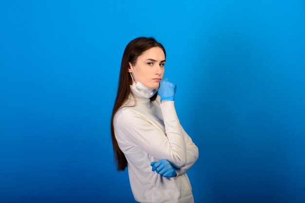 Fille en gants médicaux robe masque de protection sur son visage