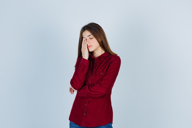 fille gardant la main sur les yeux en chemise décontractée et ayant l'air fatigué.