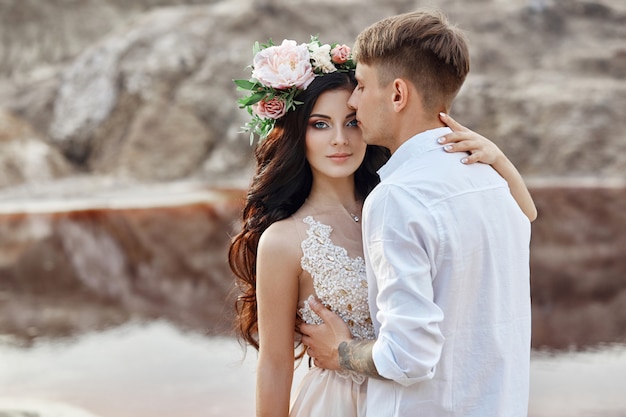 Fille avec une gerbe de fleurs sur la tête un garçon l'embrassant