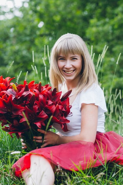 Fille avec un grand bouquet de lys violets