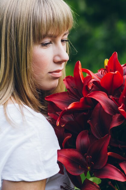 Fille avec un grand bouquet de lys violets