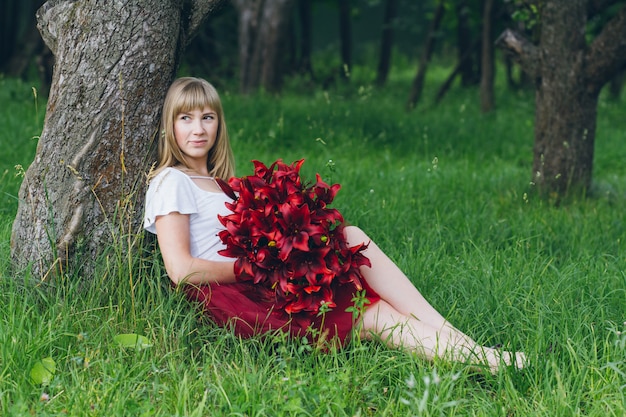 Fille avec un grand bouquet de lys violets