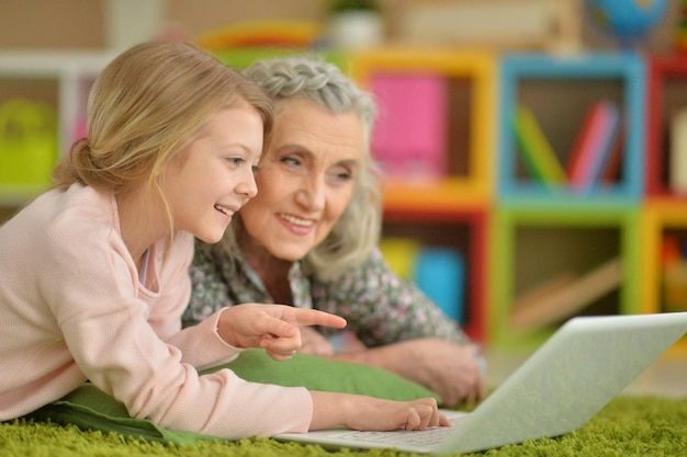 Fille avec grand-mère à l'aide d'un ordinateur portable