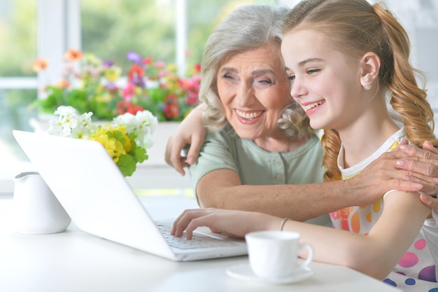 Fille avec grand-mère à l'aide de tablette