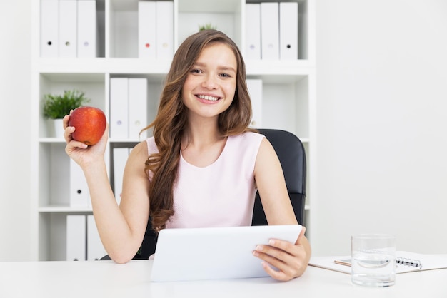 Fille avec grande tablette et pomme