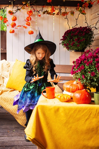 fille habillée en sorcière avec une citrouille à halloween portrait d'une sorcière