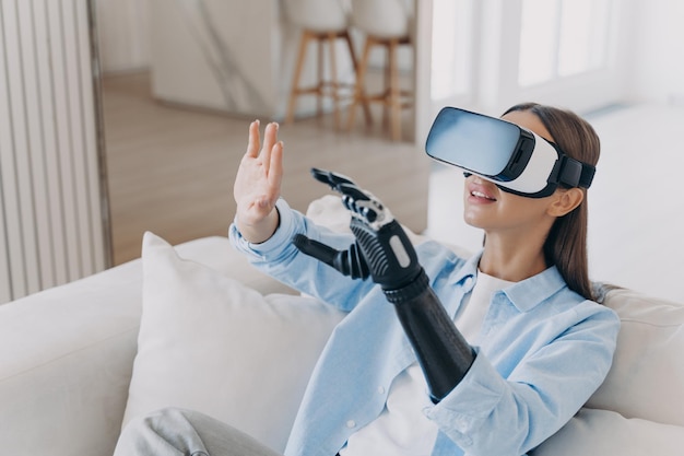 Fille handicapée dans des lunettes de réalité virtuelle jouant dans une formation de jeu vidéo pour utiliser un bras prothétique