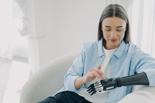 Une fille handicapée heureuse installe son membre artificiel et appuie sur des boutons Copier l'espace