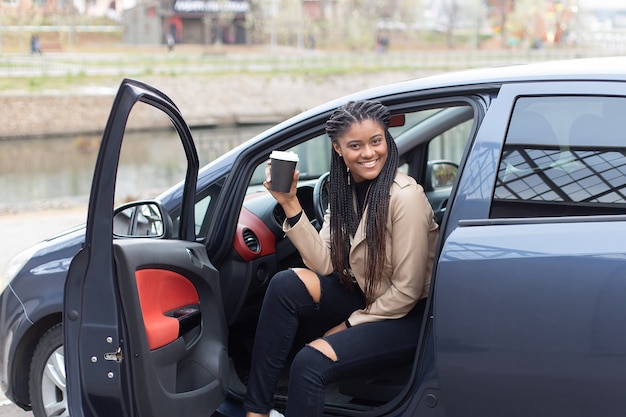 La Fille Heureuse Au Volant D'une Voiture, Boire Du Café, Afro-américain