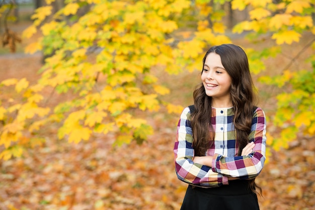 Une fille heureuse aux cheveux longs profite de la nature automnale, automne.