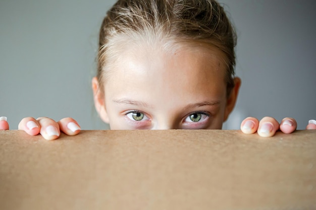 Photo une fille heureuse avec de beaux yeux verts dans une nouvelle maison avec une boîte en carton
