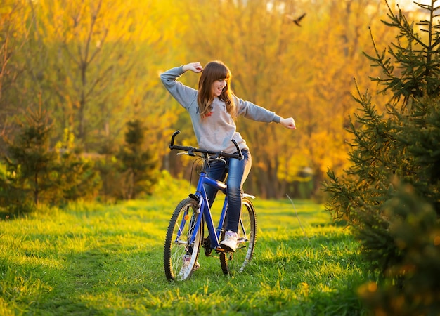 Fille heureuse avec les bras tendus sur un vélo