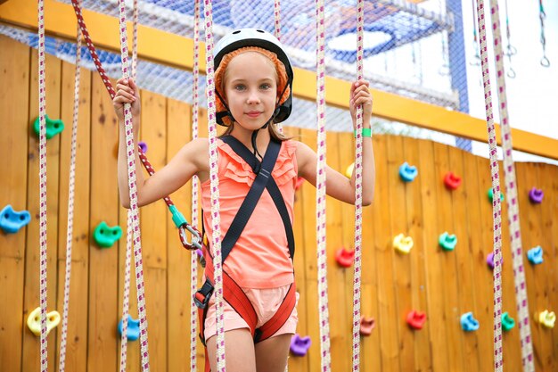 Fille heureuse sur le chemin de la corde dans le centre d'amusement pour les enfants.