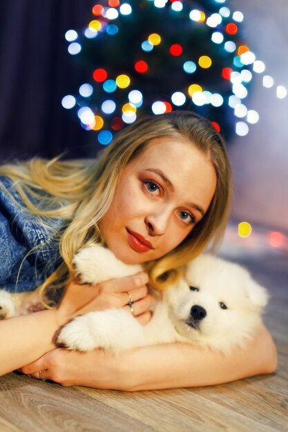 Fille heureuse avec chien husky samoyède dans les décorations de Noël