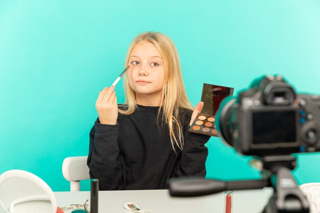 Fille heureuse dans le studio parlant devant la caméra pour vlog. Jeune femme blanche travaillant comme blogueuse, enregistrement d'un didacticiel vidéo pour Internet.