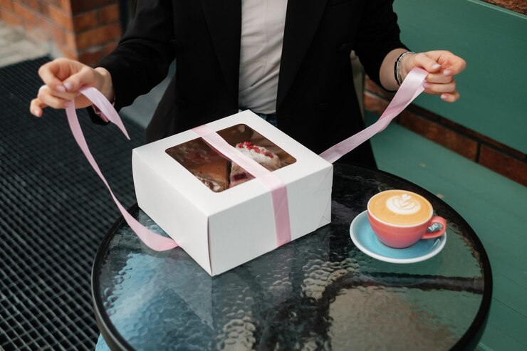 Fille heureuse déballant une boîte-cadeau dans un café d'été
