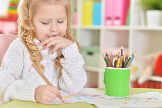 Fille heureuse dessinant avec des crayons colorés