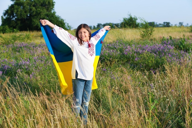 Fille heureuse avec le drapeau national de l'Ukraine dans le champ Espace pour le texte