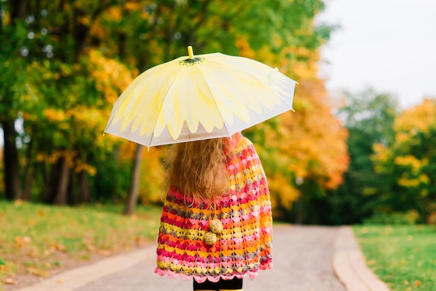 Fille heureuse d'enfant riant avec un parapluie en parc d'automne