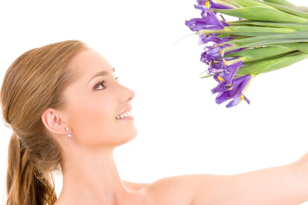 fille heureuse avec des fleurs sur un mur blanc