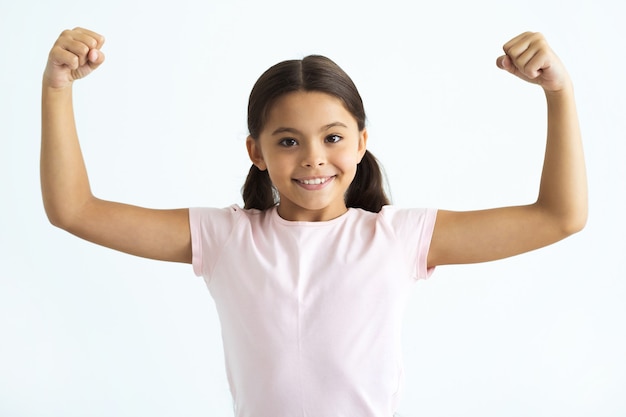 La fille heureuse gesticulant sur le fond blanc