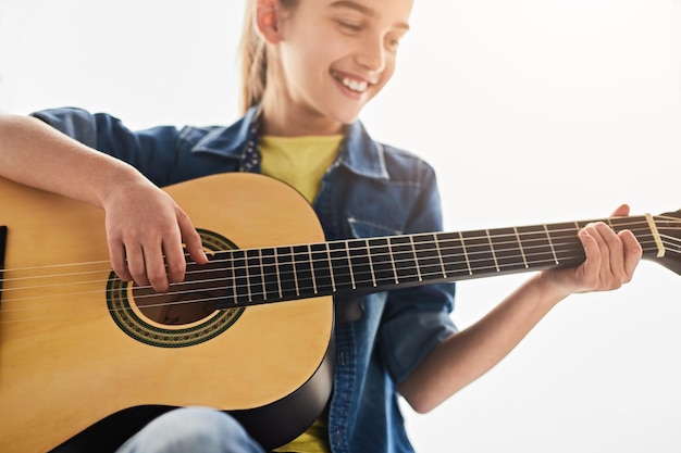 Fille heureuse jouant de la guitare pendant la journée