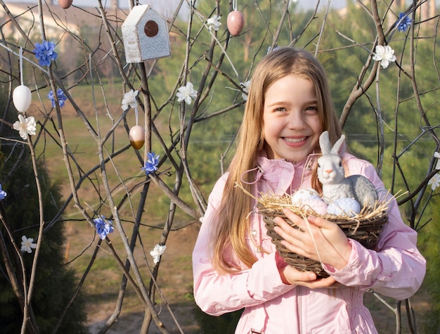 fille heureuse avec lapin de Pâques et oeufs en plein air