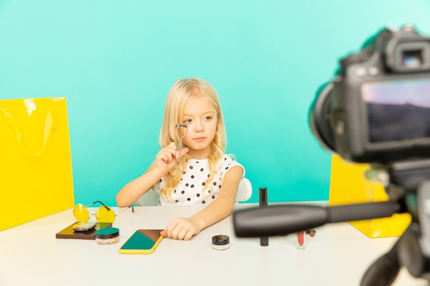 Fille heureuse à la maison parlant devant la caméra pour vlog. Petit enfant travaillant comme blogueur, enregistrant un didacticiel vidéo pour Internet.