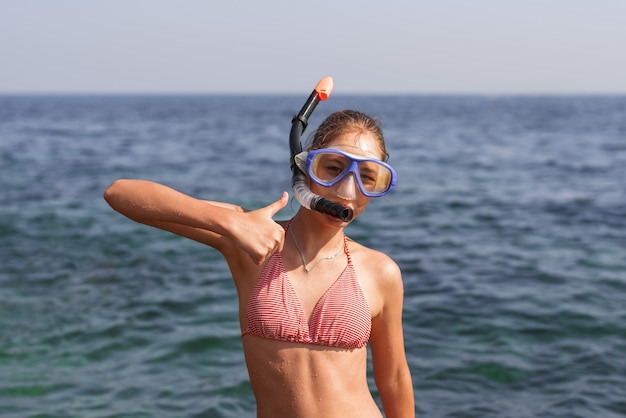 Fille heureuse en masque et tuba sur la plage