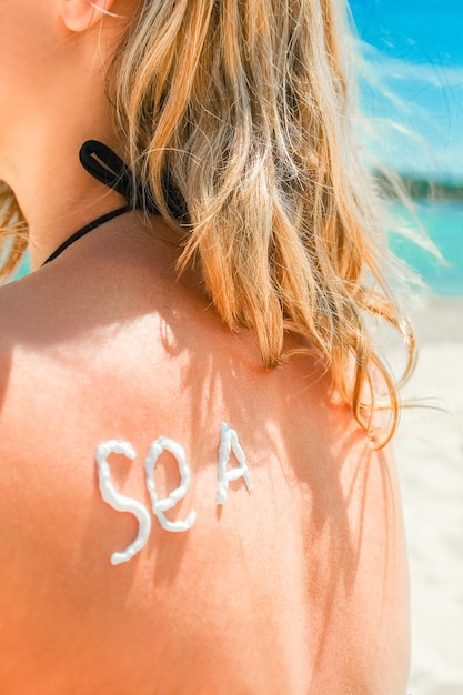 Fille heureuse sur la mer avec une photo du soleil sur le dos