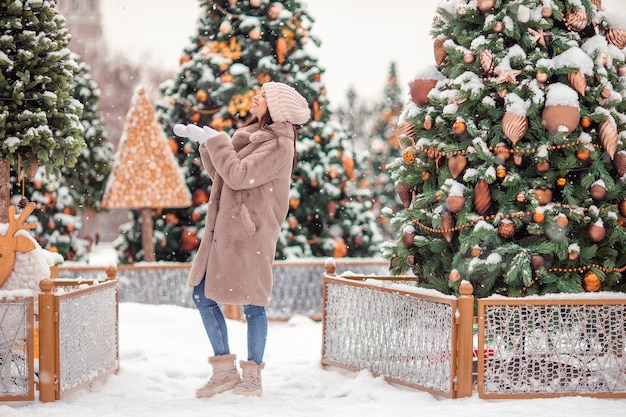 Fille heureuse près de la branche de sapin dans la neige pour le nouvel an