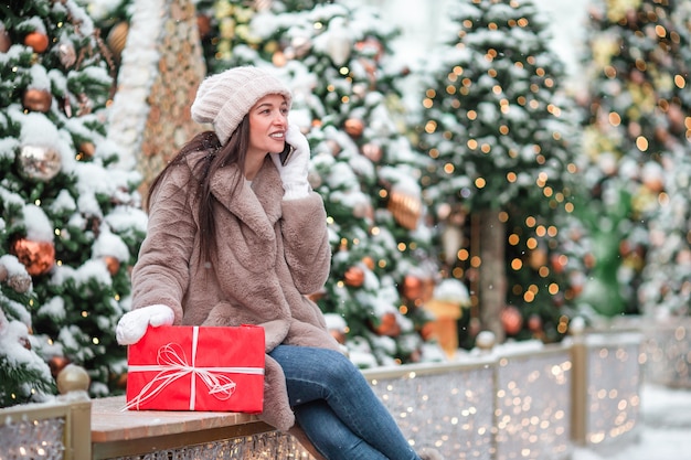 Fille heureuse près de branche de sapin dans la neige pour le nouvel an.