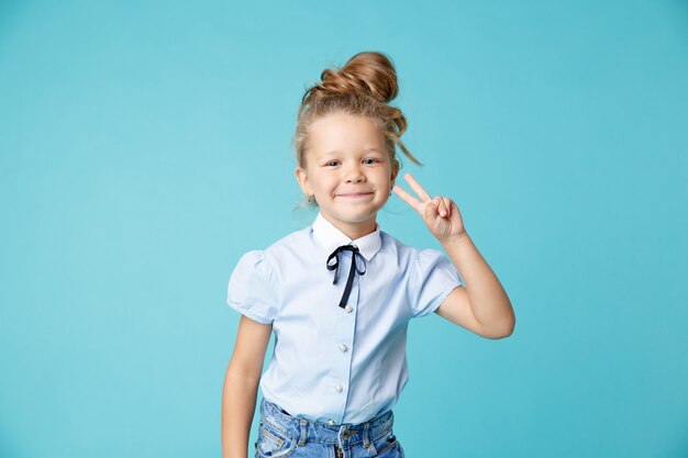 Fille heureuse qui pose en studio isolé.