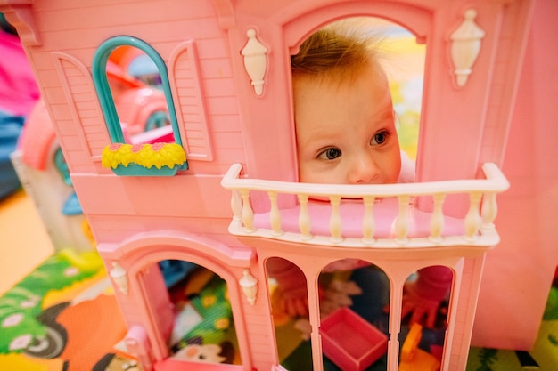 Une fille heureuse regarde par la fenêtre du palais rose