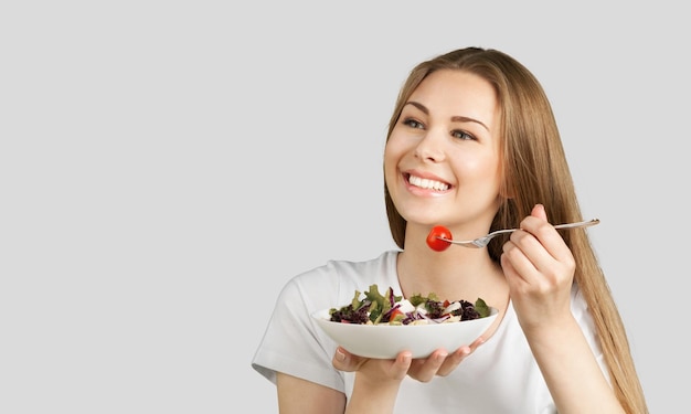 Une fille heureuse rêveuse tient une fourchette et un repas savoureux