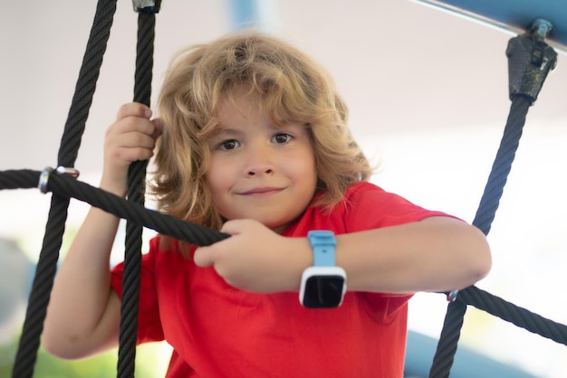 Fille heureuse s'amusant à l'aire de jeux enfant jouant dans l'aire de jeux vacances d'été pour enfants