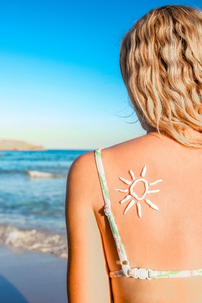 Fille heureuse avec le soleil sur le dos au bord de la mer dans la nature