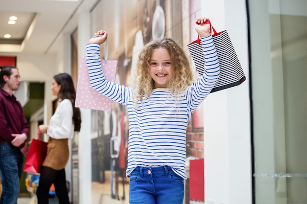 Fille heureuse tenant des sacs