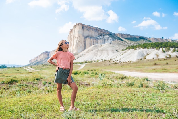 Fille heureuse en vacances d'été avec le rocher sur fond