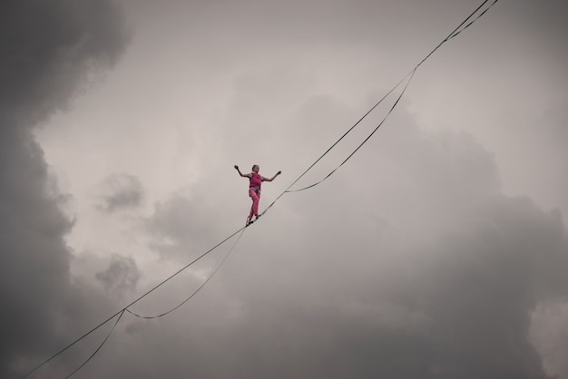 Fille de highliner sur le fond du ciel nuageux